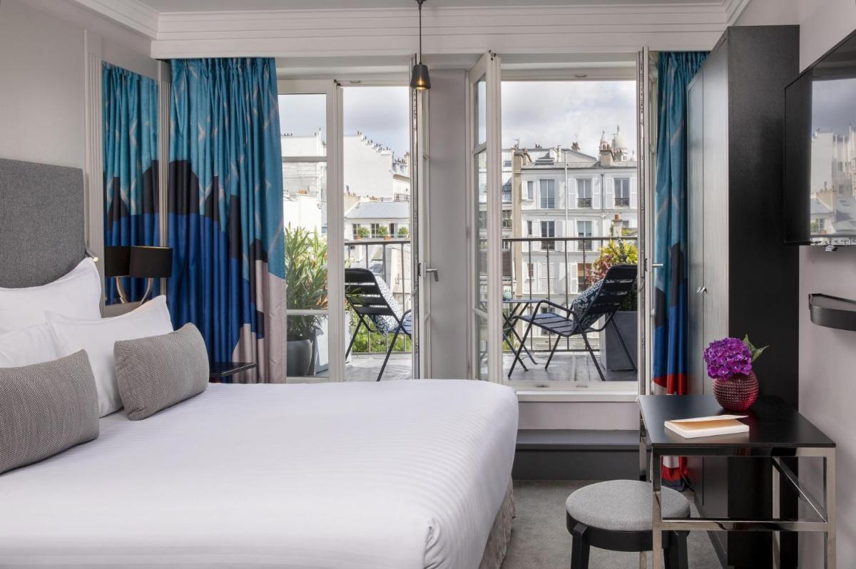 une chambre d'hôtel avec un lit et un balcon dans l'établissement Les Matins de Paris & Spa, à Paris