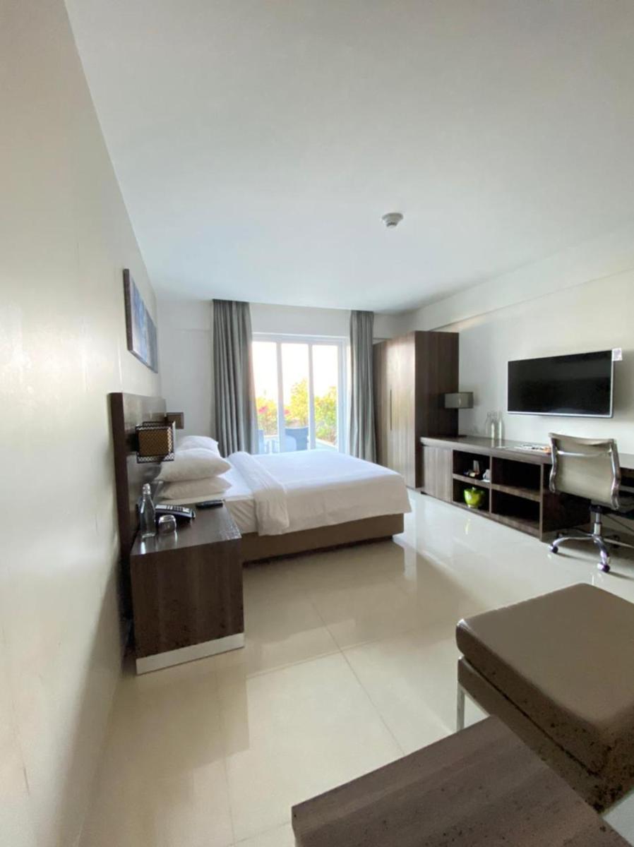 a large hotel room with a bed and a tv at The Residency Towers, Rameswaram in Rāmeswaram