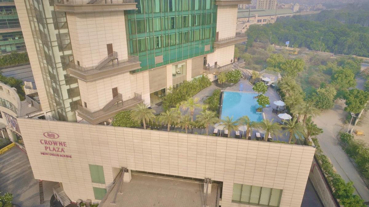 an overhead view of a building with a swimming pool at Crowne Plaza New Delhi Rohini by IHG in New Delhi an overhead view of a building with a swimming pool at Crowne Plaza New Delhi Rohini by IHG in New Delhi