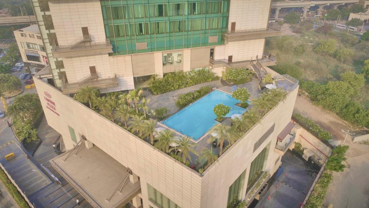 an overhead view of a building with a swimming pool at Crowne Plaza New Delhi Rohini by IHG in New Delhi an overhead view of a building with a swimming pool at Crowne Plaza New Delhi Rohini by IHG in New Delhi