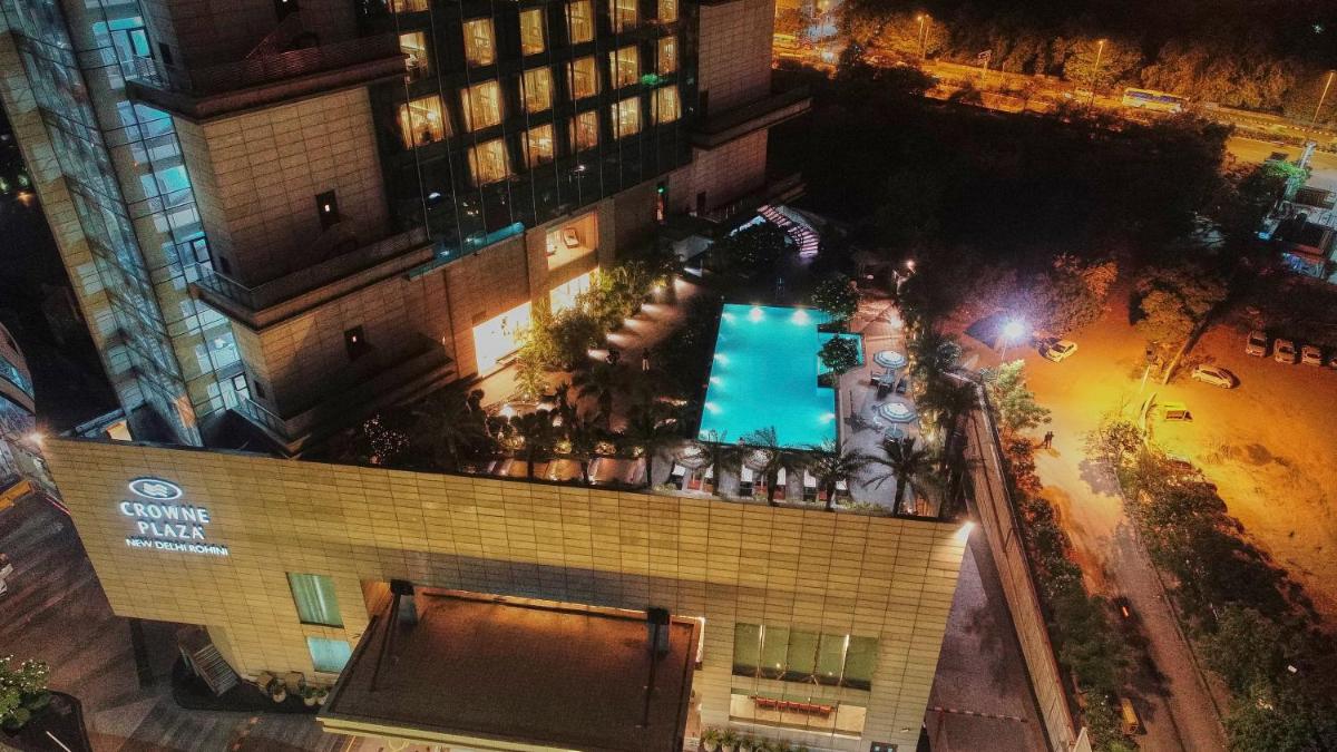 an overhead view of a building with a swimming pool at Crowne Plaza New Delhi Rohini by IHG in New Delhi an overhead view of a building with a swimming pool at Crowne Plaza New Delhi Rohini by IHG in New Delhi