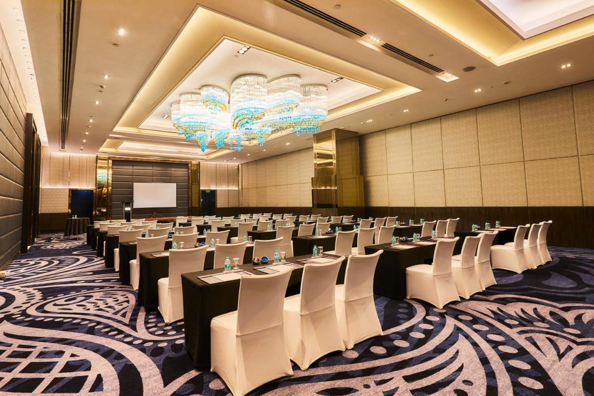 a conference room with rows of tables and chairs at Crowne Plaza New Delhi Rohini by IHG in New Delhi a conference room with rows of tables and chairs at Crowne Plaza New Delhi Rohini by IHG in New Delhi