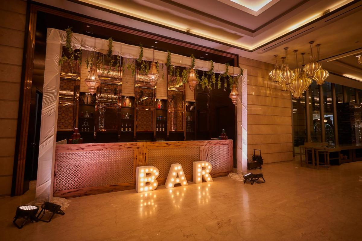 a bar with a bar sign in the middle of a room at Crowne Plaza New Delhi Rohini by IHG in New Delhi a bar with a bar sign in the middle of a room at Crowne Plaza New Delhi Rohini by IHG in New Delhi