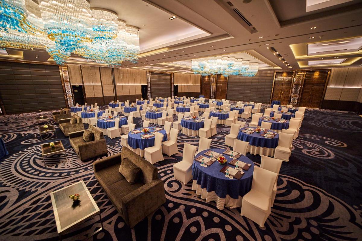 a banquet hall with blue and white tables and chairs at Crowne Plaza New Delhi Rohini by IHG in New Delhi a banquet hall with blue and white tables and chairs at Crowne Plaza New Delhi Rohini by IHG in New Delhi