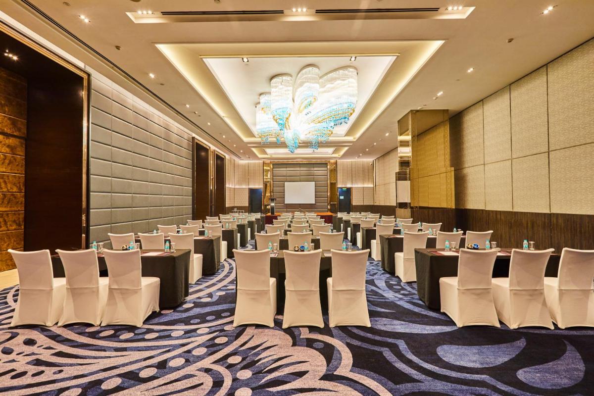 a conference room with rows of tables and chairs at Crowne Plaza New Delhi Rohini by IHG in New Delhi a conference room with rows of tables and chairs at Crowne Plaza New Delhi Rohini by IHG in New Delhi