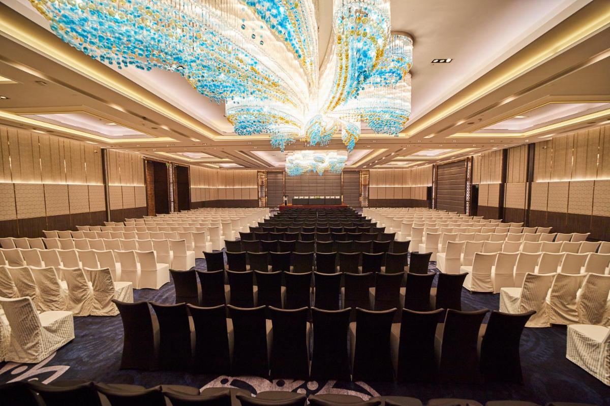 a large banquet hall with chairs and a large chandelier at Crowne Plaza New Delhi Rohini by IHG in New Delhi a large banquet hall with chairs and a large chandelier at Crowne Plaza New Delhi Rohini by IHG in New Delhi