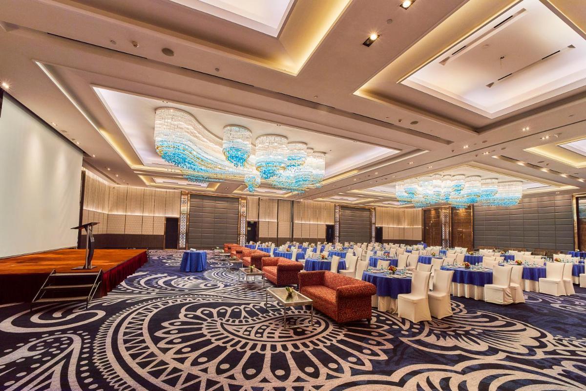 a banquet hall with tables and chairs and a stage at Crowne Plaza New Delhi Rohini by IHG in New Delhi a banquet hall with tables and chairs and a stage at Crowne Plaza New Delhi Rohini by IHG in New Delhi