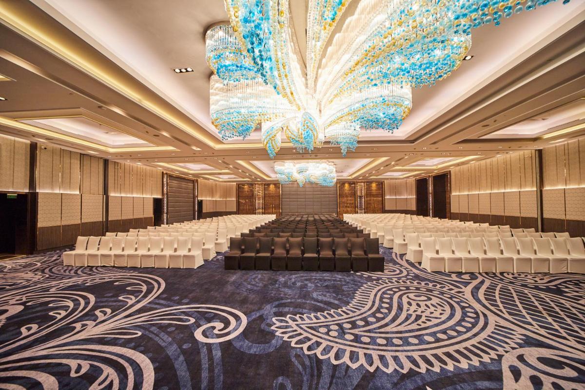 a banquet hall with white chairs and a large chandelier at Crowne Plaza New Delhi Rohini by IHG in New Delhi a banquet hall with white chairs and a large chandelier at Crowne Plaza New Delhi Rohini by IHG in New Delhi