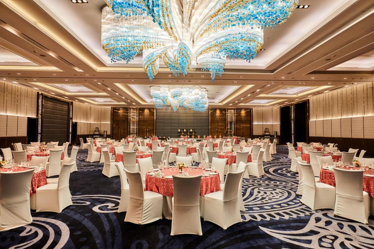 a ballroom with tables and chairs and a chandelier at Crowne Plaza New Delhi Rohini by IHG in New Delhi +204 photos a ballroom with tables and chairs and a chandelier at Crowne Plaza New Delhi Rohini by IHG in New Delhi +204 photos