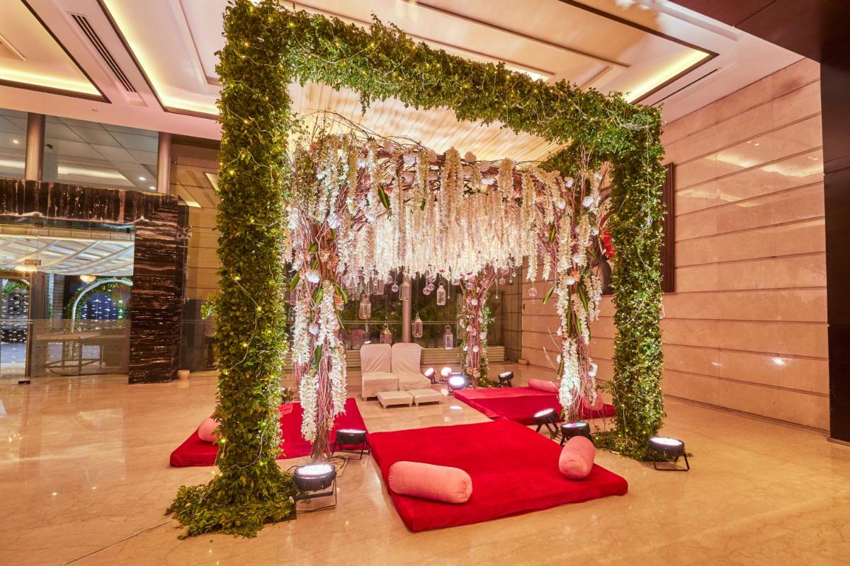 a wedding arch with a red carpet and flowers at Crowne Plaza New Delhi Rohini by IHG in New Delhi a wedding arch with a red carpet and flowers at Crowne Plaza New Delhi Rohini by IHG in New Delhi