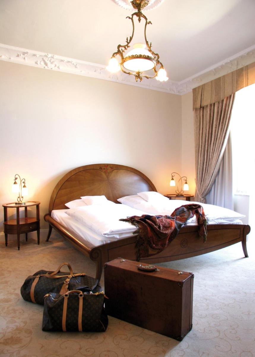 ein Schlafzimmer mit einem großen Bett und einem Koffer in der Unterkunft Hotel Miramar in Westerland + 37 Fotos