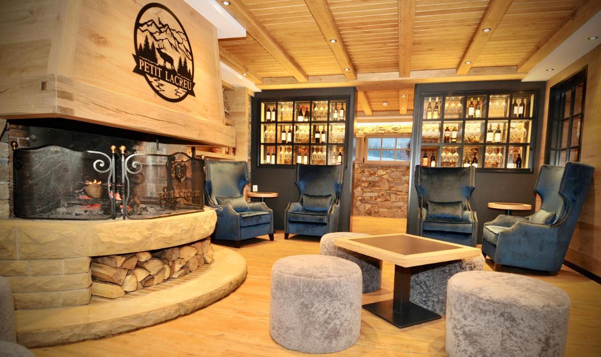 un bar con sillas azules y una chimenea de piedra en Hotel Petit Lacreu, en Salardú