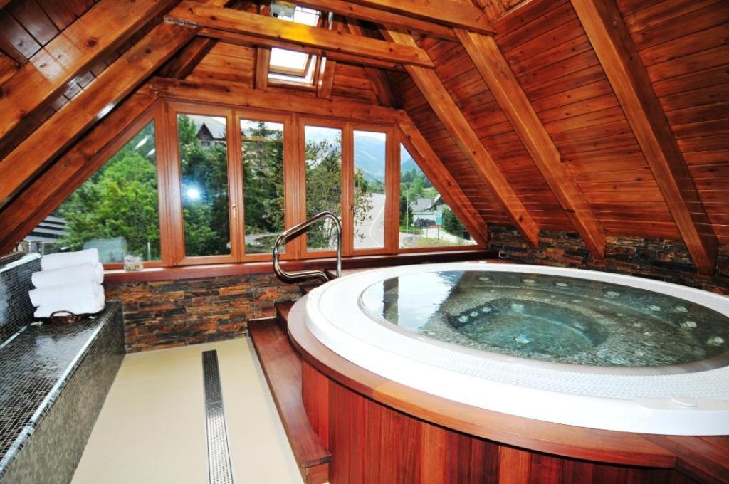 baño grande con bañera grande en el techo de madera en Hotel Petit Lacreu, en Salardú