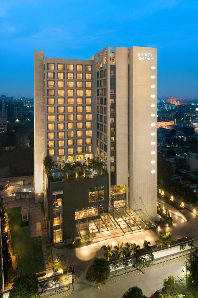 a large hotel building with a night view of a city at Hyatt Regency Lucknow Gomti Nagar in Lucknow