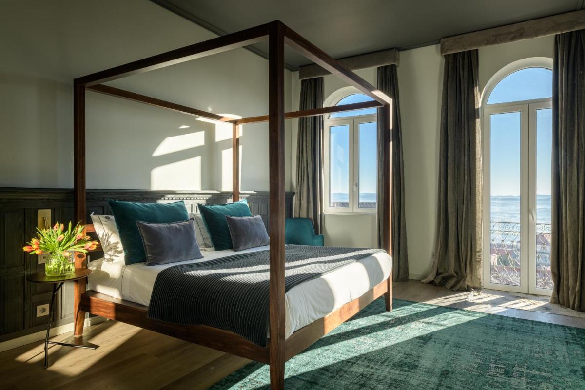 um quarto com uma cama de dossel e vista para o oceano em Pena D'Água Boutique Hotel & Villas na Covilhã