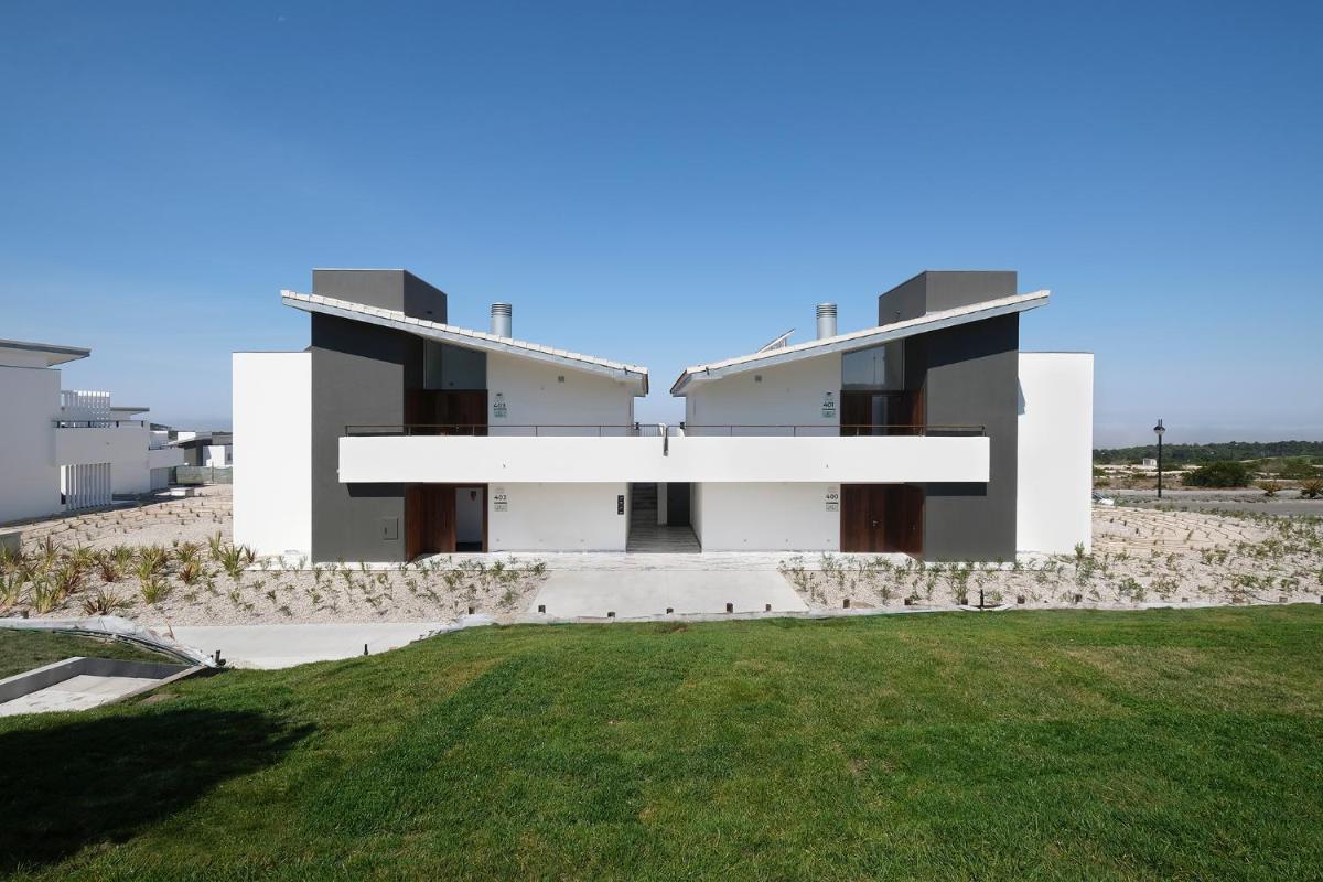 uma grande casa branca com um relvado verde em Royal Obidos Scenic Resort em Praia del Rei