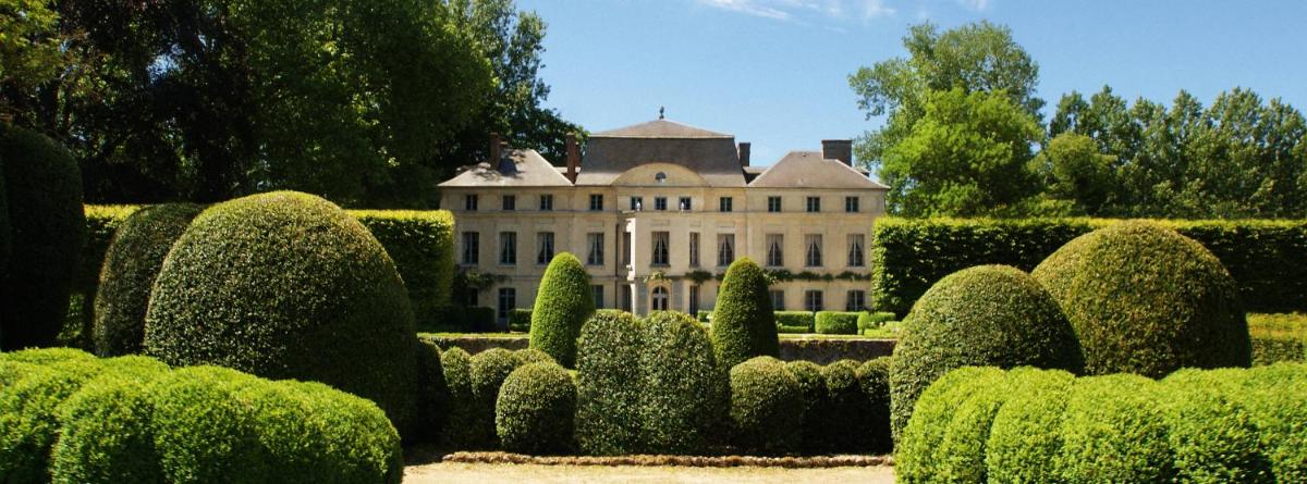 une grande maison au milieu d'un jardin dans l'établissement Le Domaine de Primard, à Guainville
