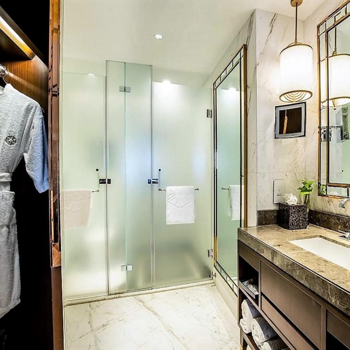 a bathroom with a glass shower and a sink at Taj MG Road Bengaluru in Bengaluru a bathroom with a glass shower and a sink at Taj MG Road Bengaluru in Bengaluru