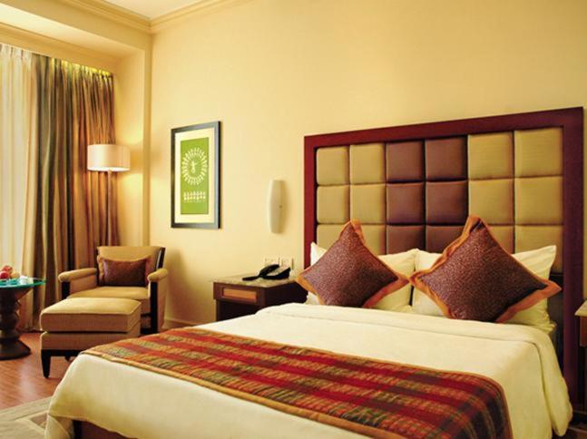 a hotel room with a large bed and a chair at Blue Diamond Pune IHCL SeleQtions in Pune