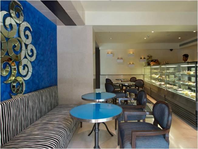 a restaurant with tables and chairs and a counter at Blue Diamond Pune IHCL SeleQtions in Pune