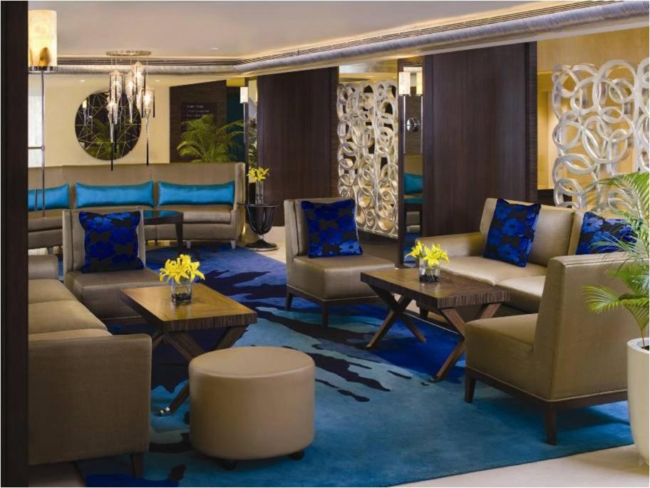 a living room with couches and chairs and tables at Blue Diamond Pune IHCL SeleQtions in Pune