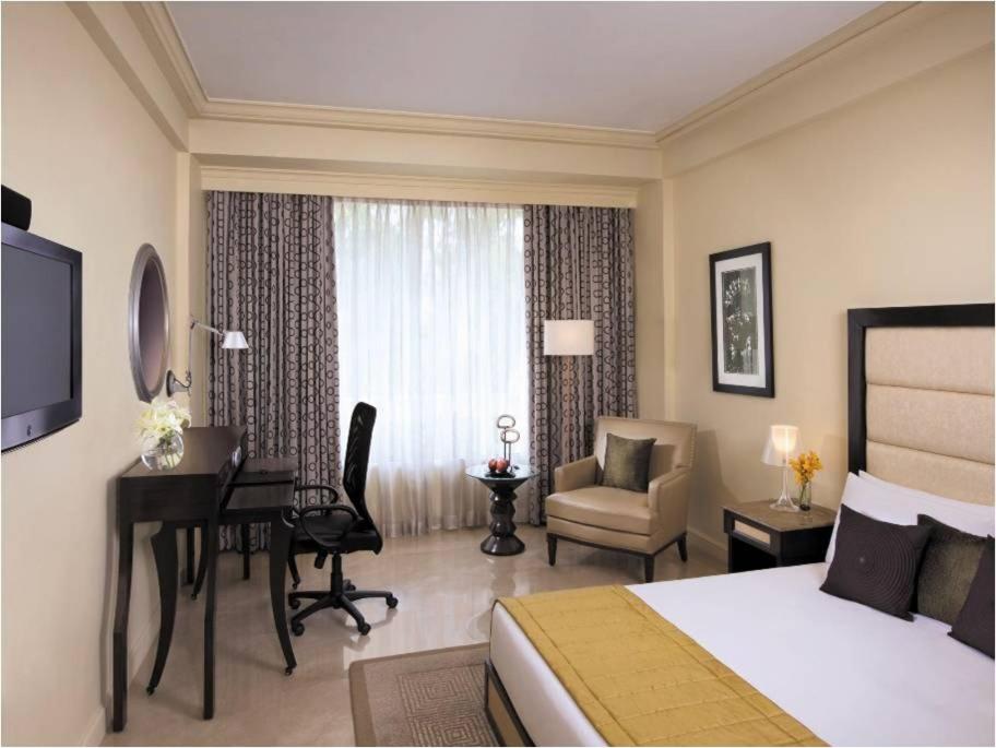 a hotel room with a bedroom with a bed and a desk at Blue Diamond Pune IHCL SeleQtions in Pune