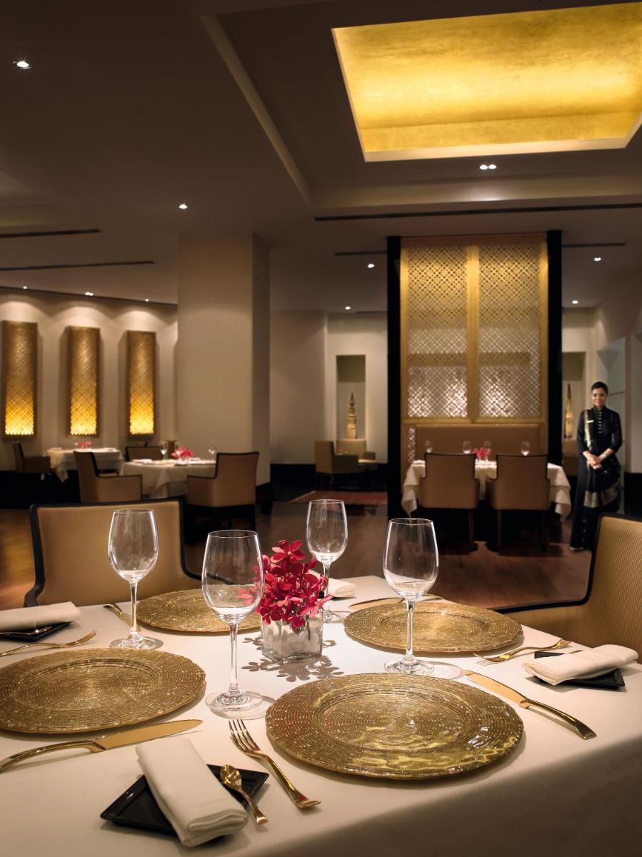 a table with wine glasses on it in a restaurant at The Oberoi Mumbai in Mumbai