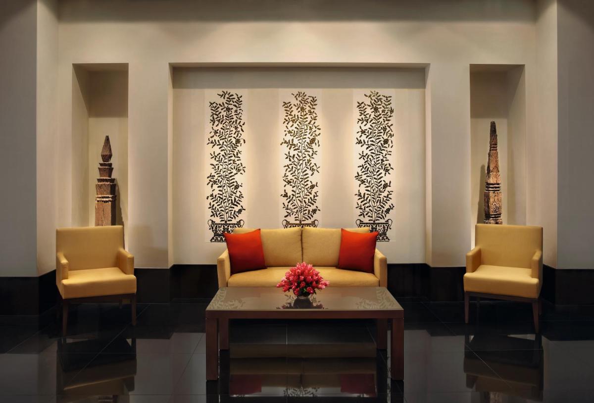 a living room with a couch and two chairs at The Oberoi Mumbai in Mumbai