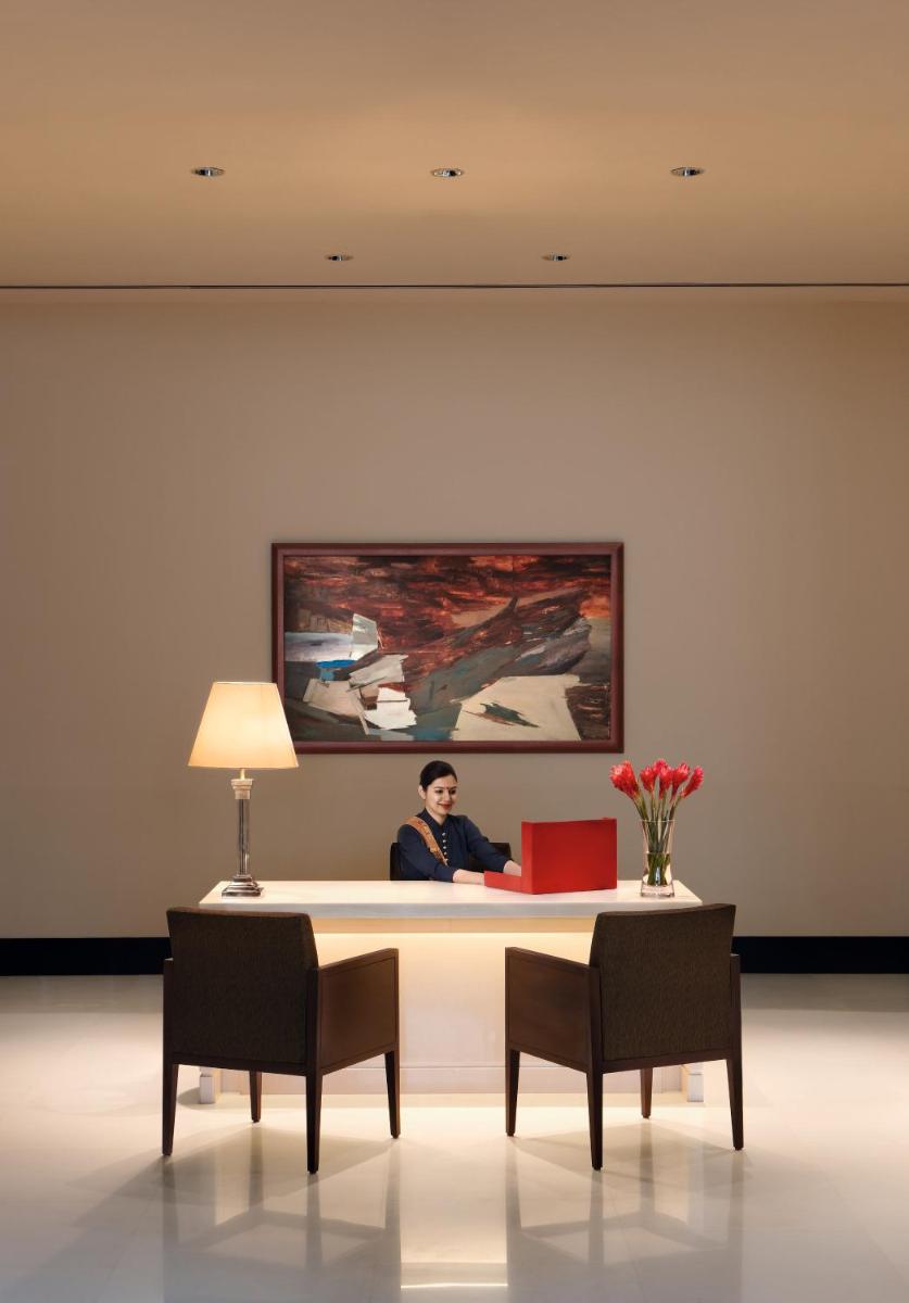 a man sitting at a desk in a room at The Oberoi Mumbai in Mumbai