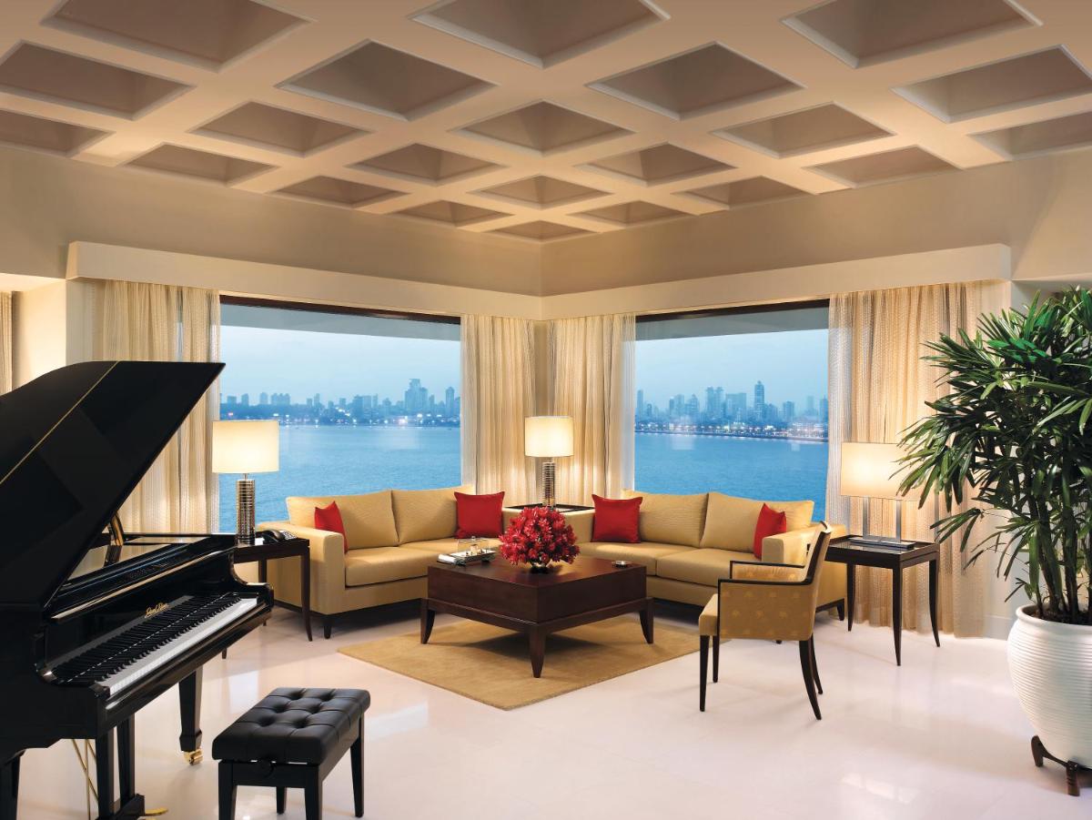 a living room with a couch and a piano at The Oberoi Mumbai in Mumbai