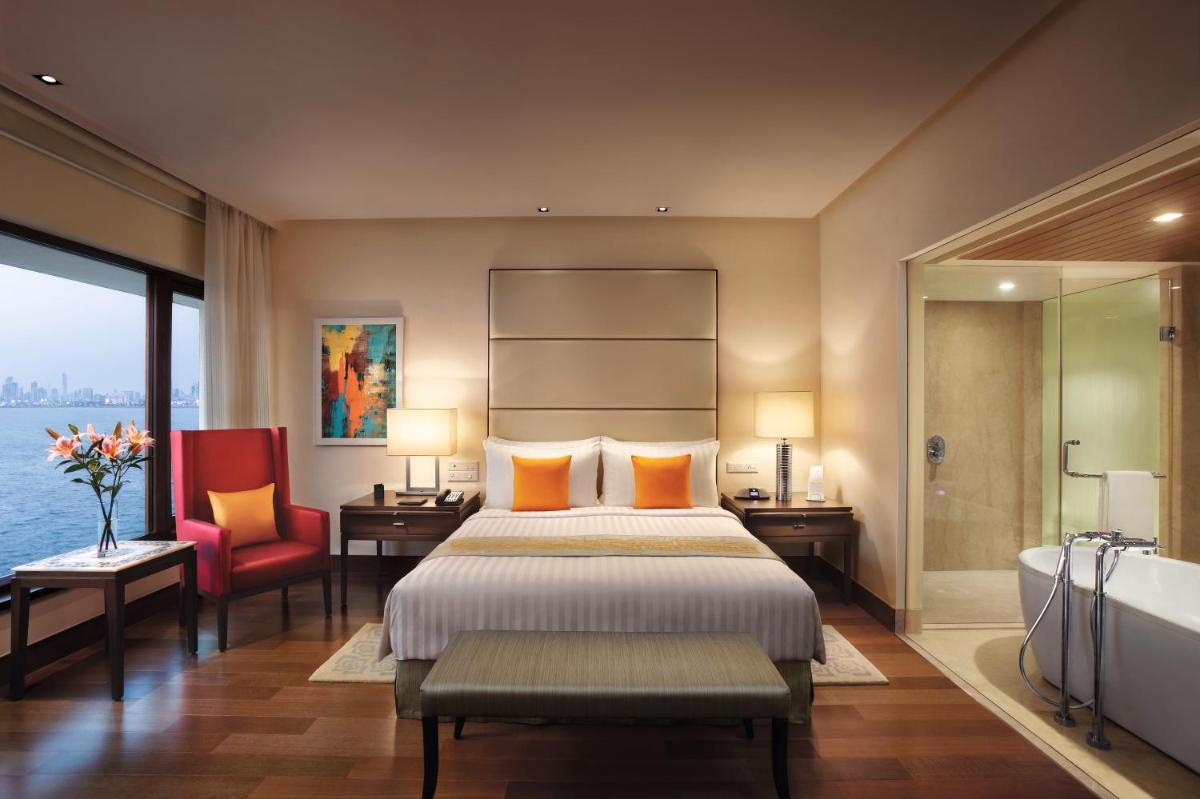 a hotel room with a bed and a bath tub at The Oberoi Mumbai in Mumbai