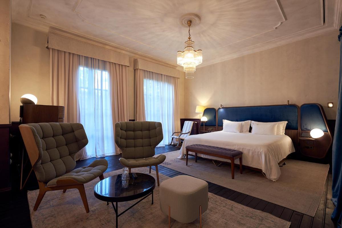 Una habitación de hotel con una cama, una mesa y sillas. en Can Bordoy Grand House Hotel GL Preferred Hotel, en Palma de Mallorca