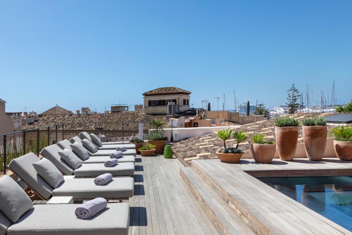 una fila de tumbonas en un patio con piscina en Can Bordoy Grand House Hotel GL Preferred Hotel, en Palma de Mallorca