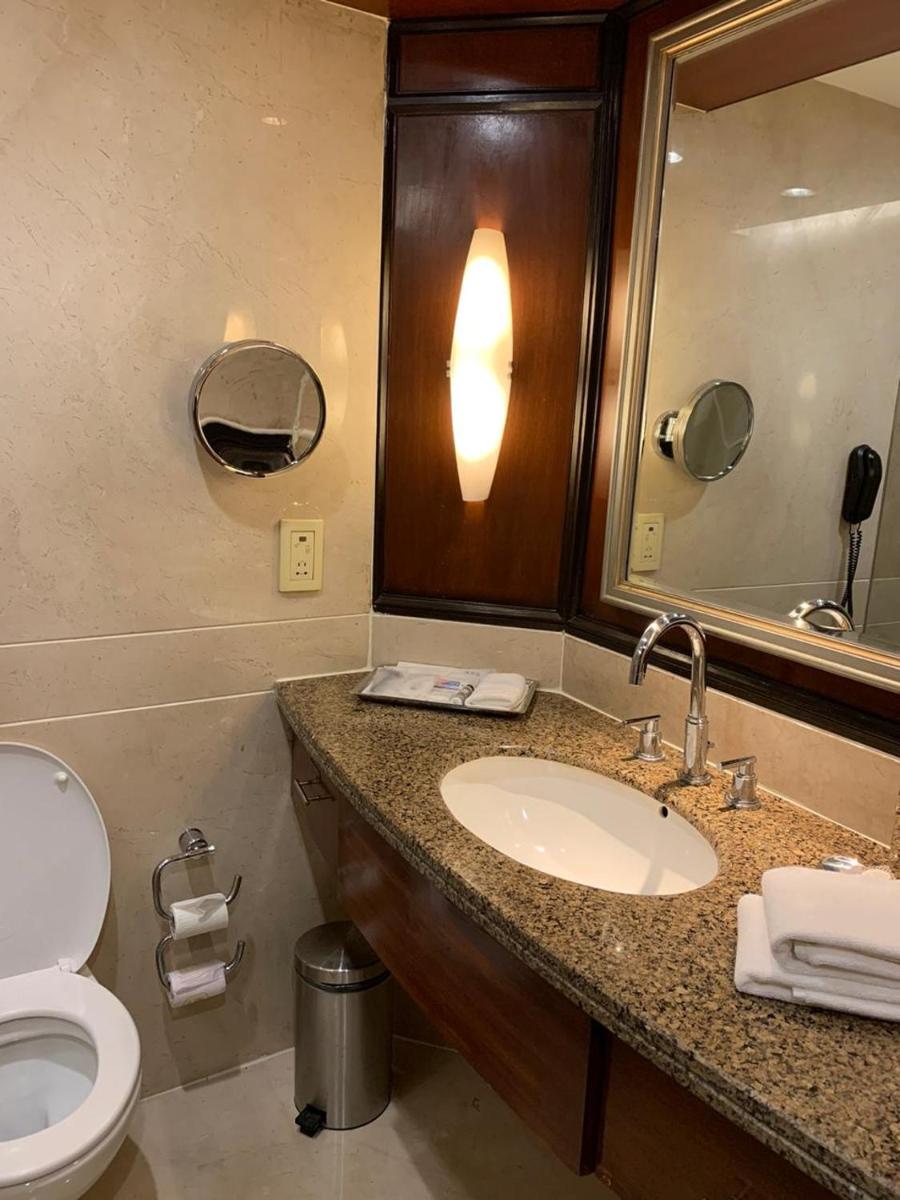 a bathroom with a sink and a toilet and a mirror at Blue Diamond Pune IHCL SeleQtions in Pune