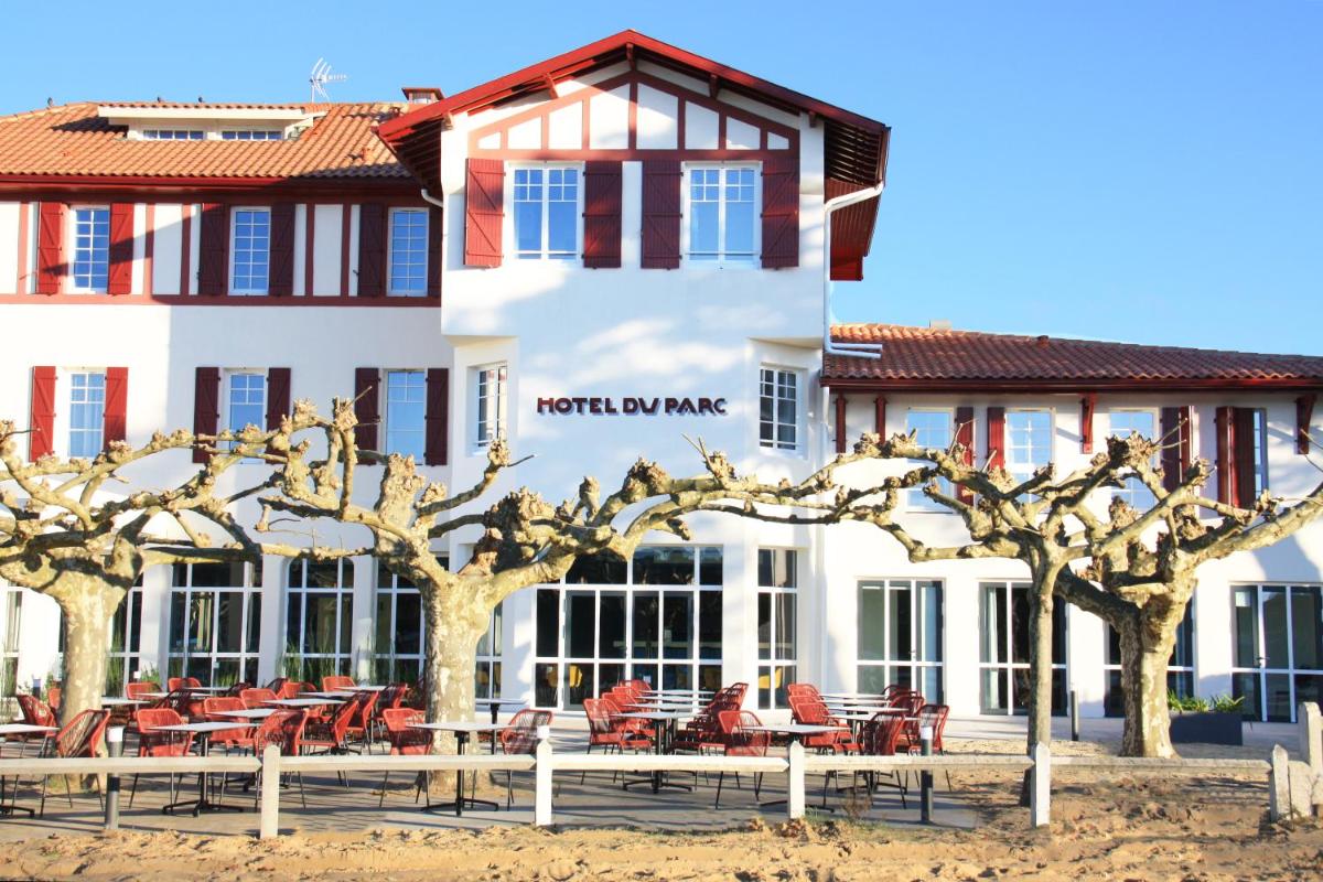 un hôtel avec des arbres devant un bâtiment dans l'établissement Hôtel du Parc & Spa, à Hossegor