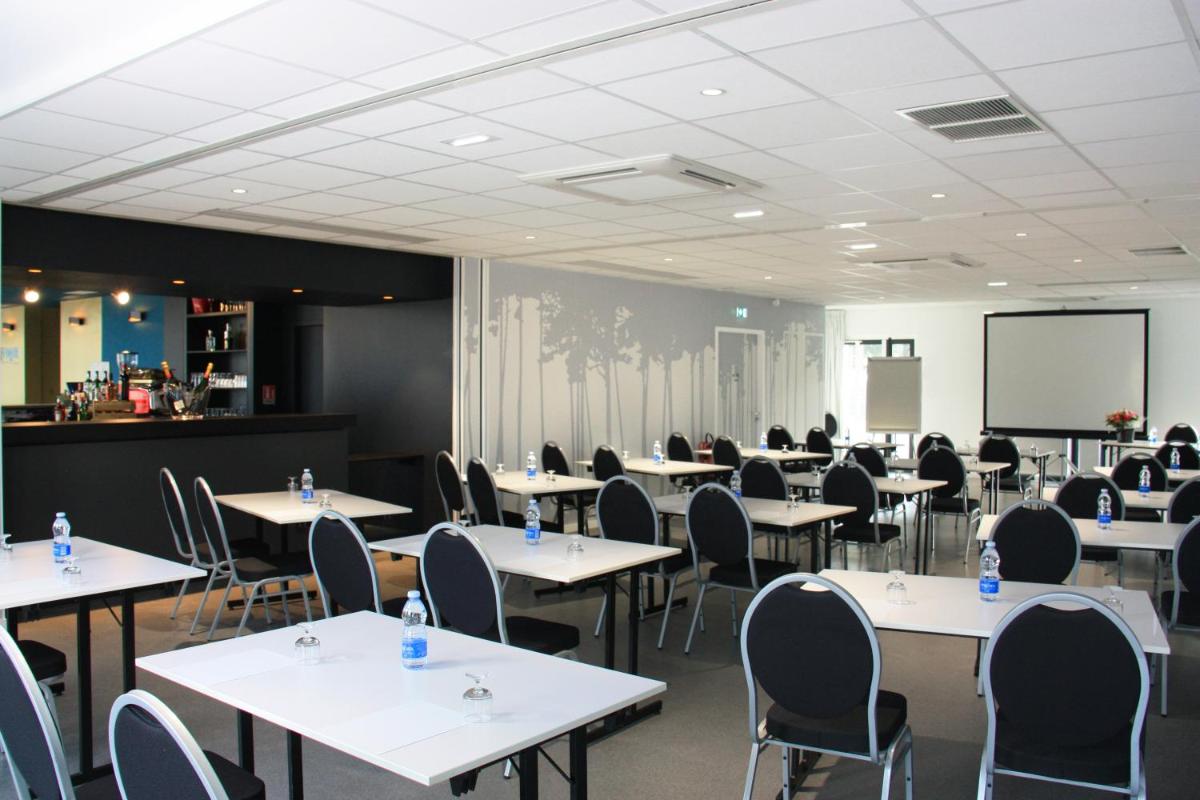 une salle de classe avec des tables, des chaises et un tableau noir dans l'établissement Hôtel du Parc & Spa, à Hossegor
