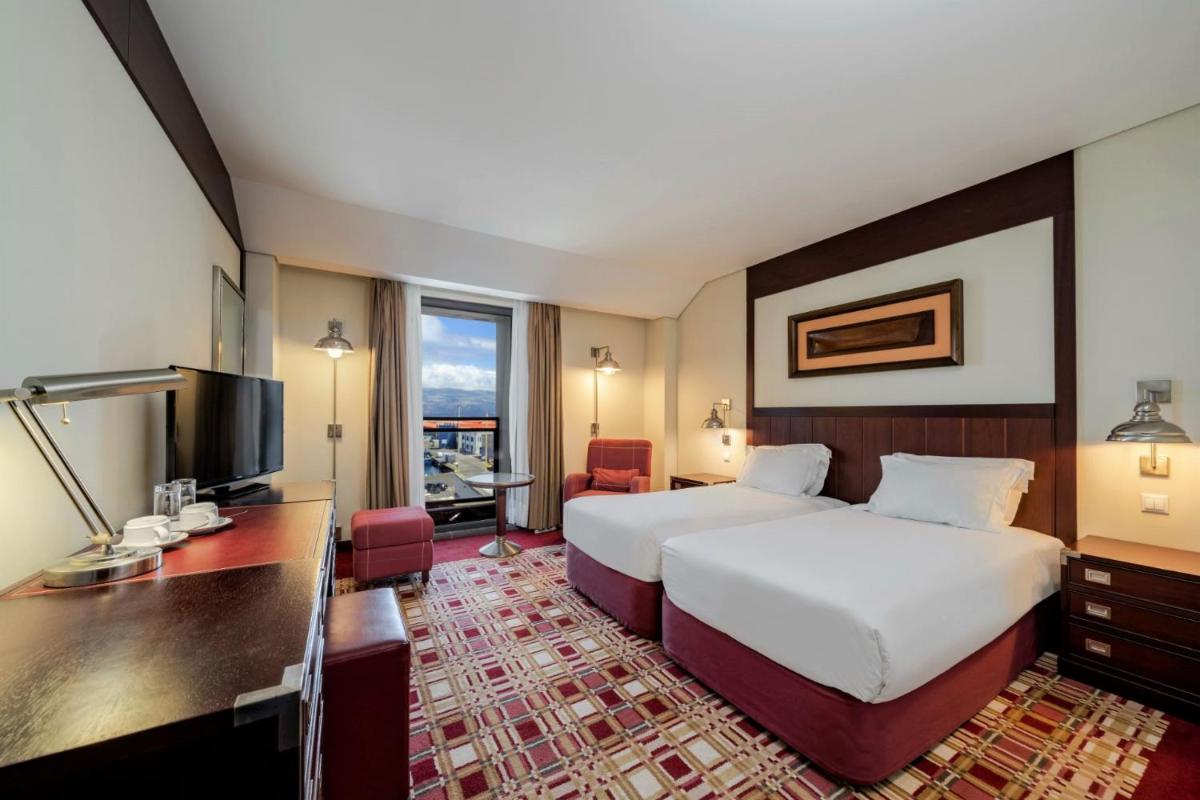 um quarto de hotel com uma cama e uma escrivaninha em Hotel do Canal em Horta mais 29 fotografias