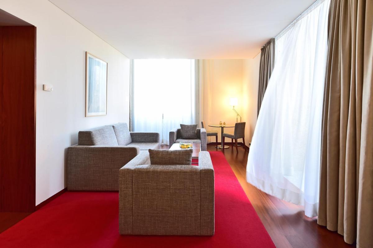 uma sala de estar com um sofá e um tapete vermelho em Pousada De Viseu em Viseu
