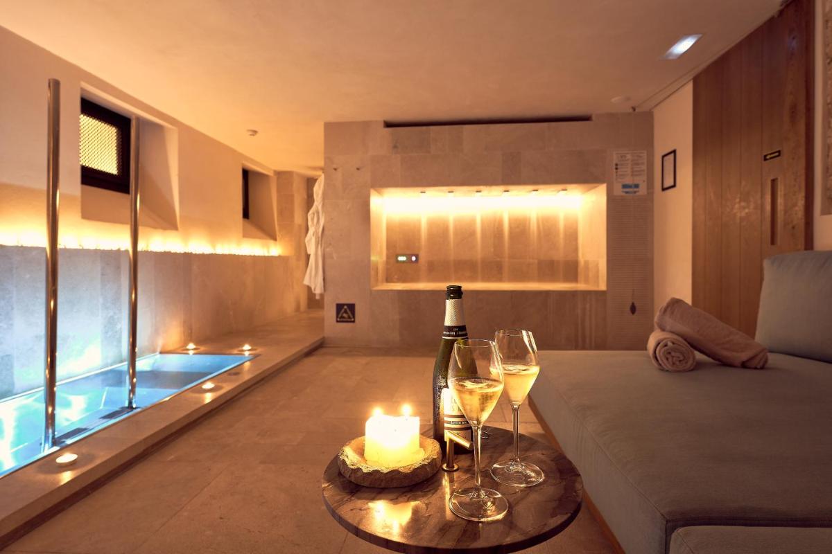 una sala de estar con una mesa con copas de vino y velas en Can Bordoy Grand House Hotel GL Preferred Hotel, en Palma de Mallorca