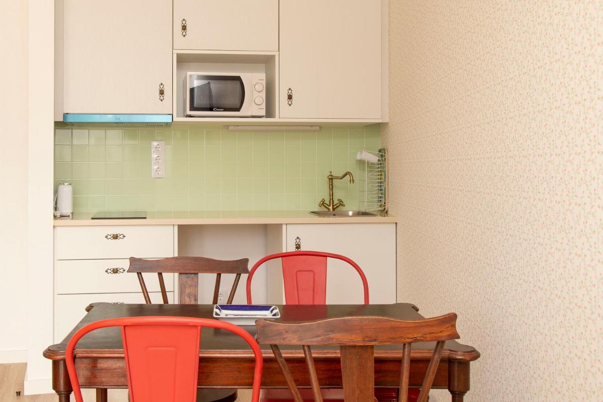 uma cozinha com uma mesa com cadeiras e um micro-ondas em Aires da Serra Hotel em Torres Novas