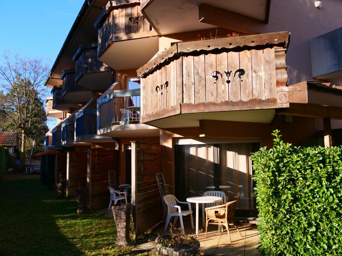 un bâtiment avec une table et des chaises devant dans l'établissement Résidence Côté Chalet, à Thonon-les-Bains