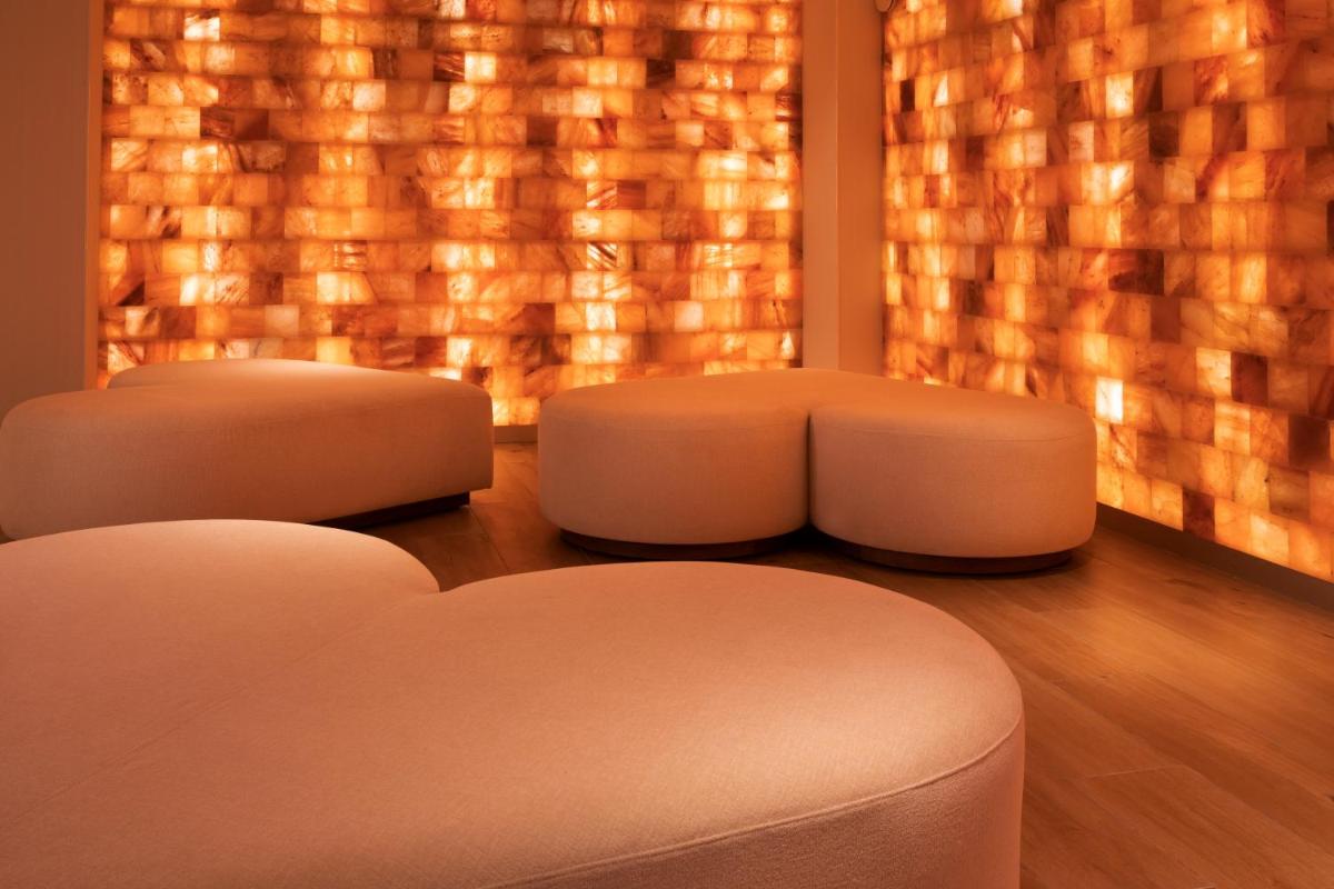 deux tabourets blancs devant une fenêtre éclairée dans l'établissement Paris j'Adore Hotel & Spa, à Paris