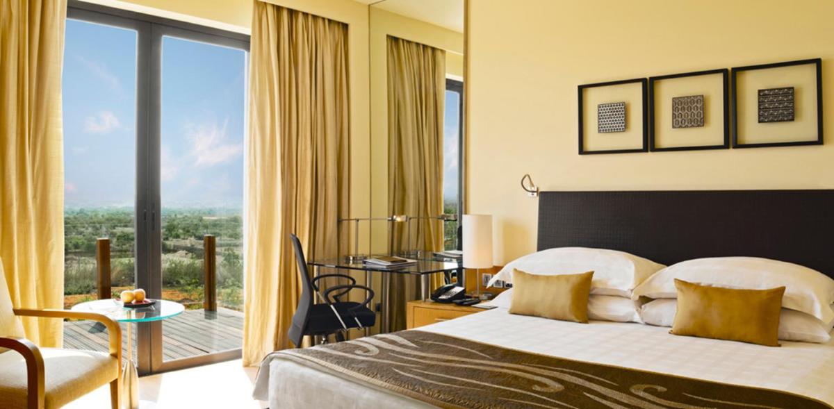 a hotel room with a bed and a balcony at Hyatt Hyderabad Gachibowli in Hyderabad