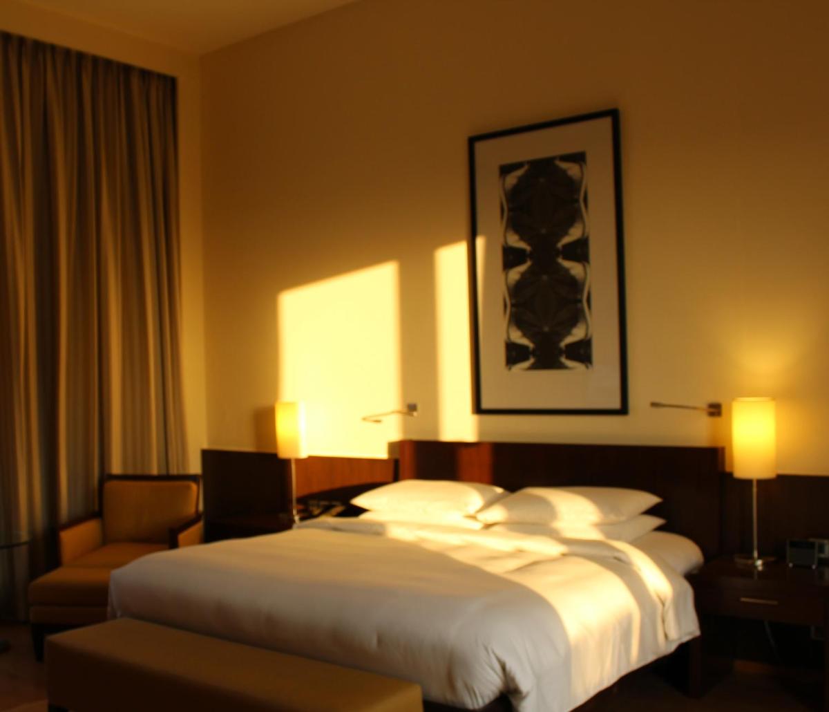 a hotel room with a bed and a chair at Hyatt Hyderabad Gachibowli in Hyderabad