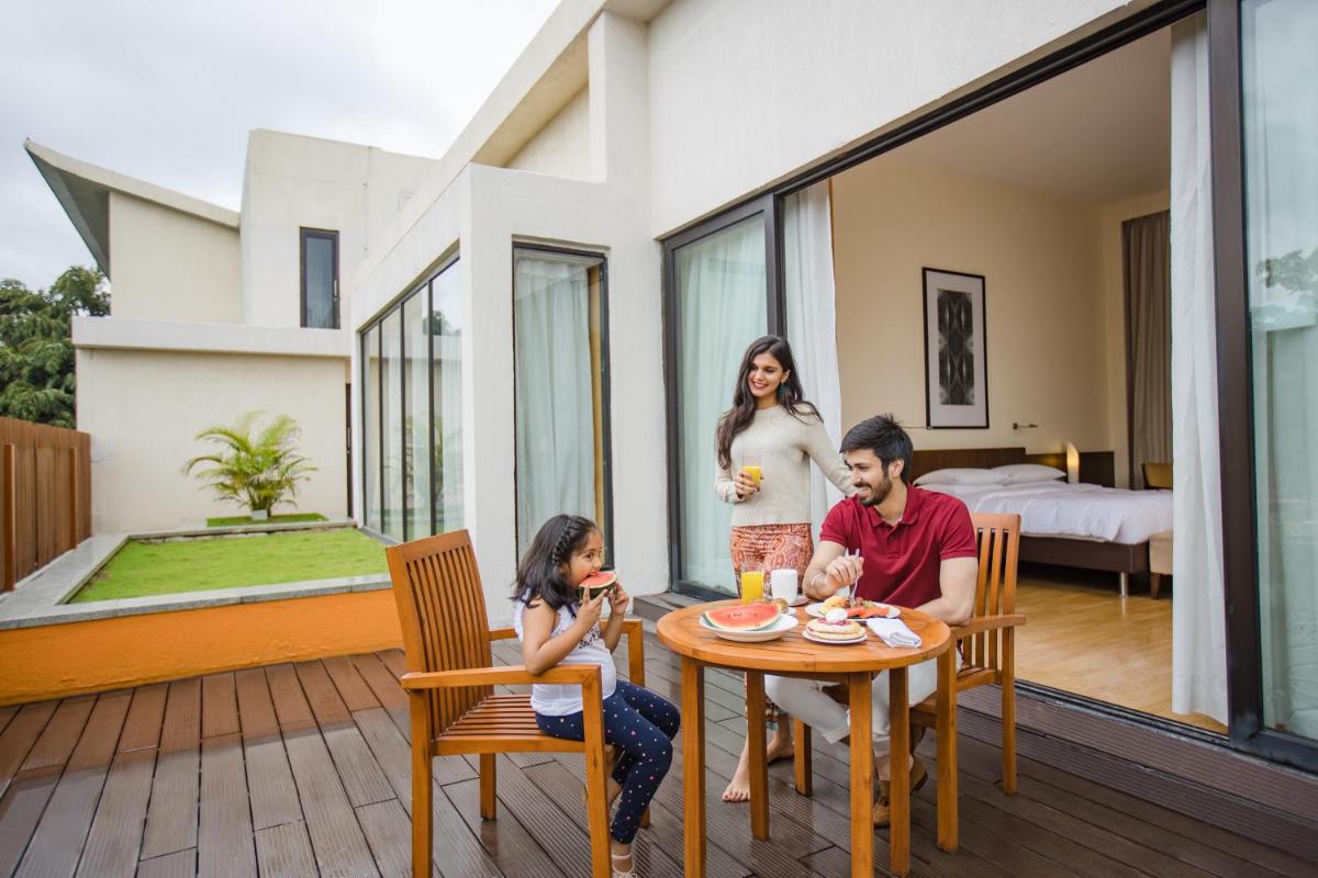 a group of people sitting around a table on a patio at Hyatt Hyderabad Gachibowli in Hyderabad