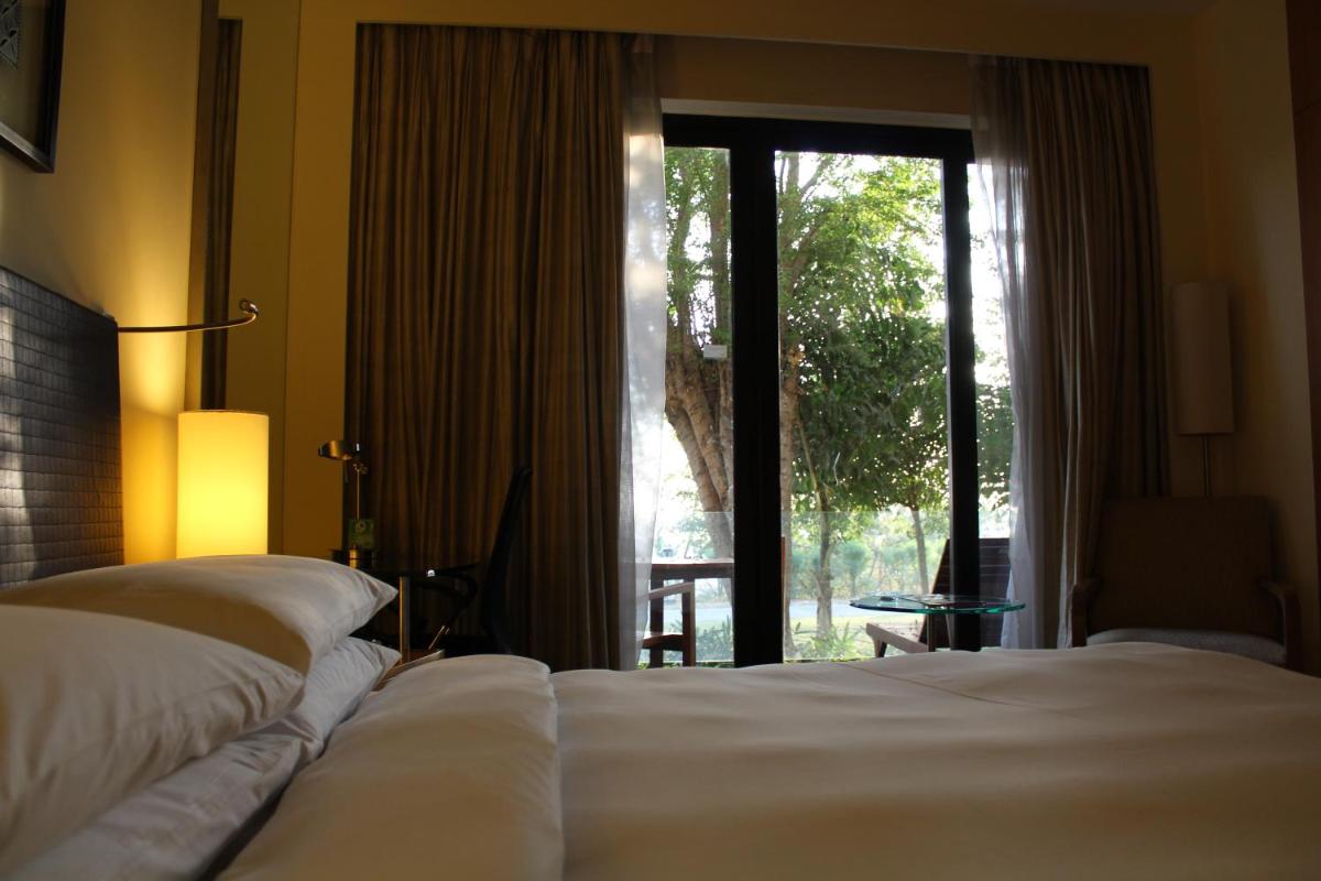 a bedroom with two beds and a large window at Hyatt Hyderabad Gachibowli in Hyderabad