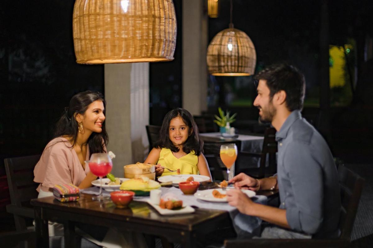 a group of people sitting at a table eating food at Hyatt Hyderabad Gachibowli in Hyderabad
