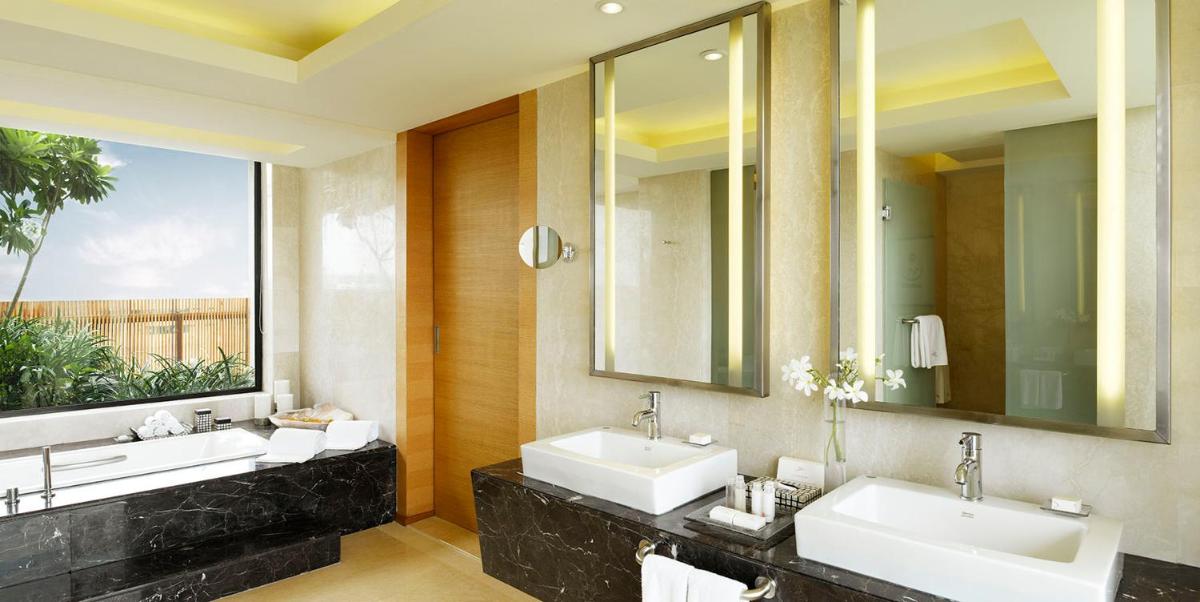 a bathroom with two sinks and a large window at Hyatt Hyderabad Gachibowli in Hyderabad