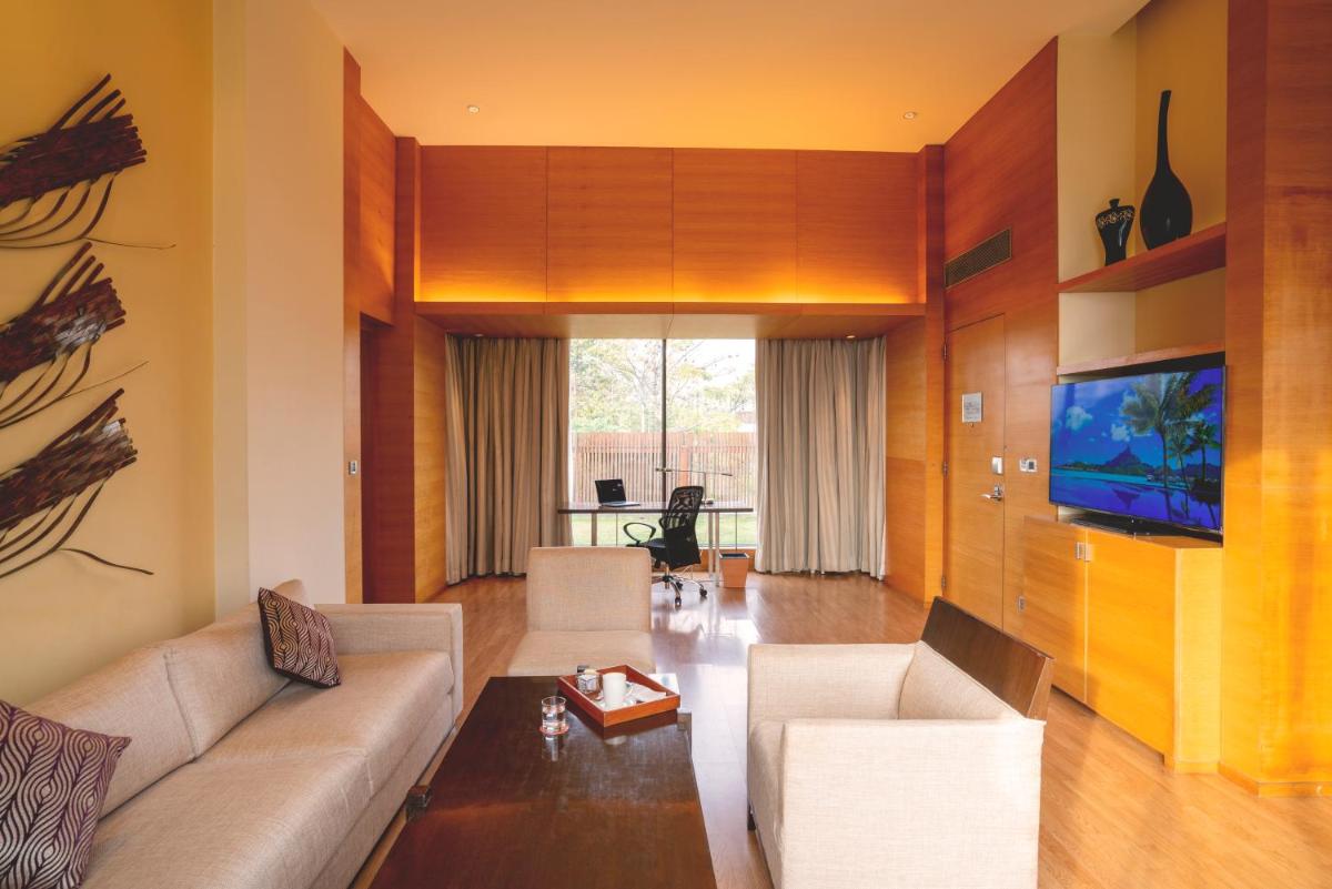 a living room with a couch and a tv at Hyatt Hyderabad Gachibowli in Hyderabad