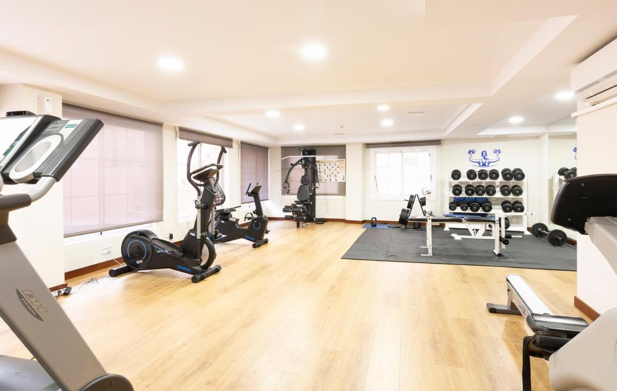 un gimnasio con cintas de correr y bicicletas estáticas en Aparthotel Los Girasoles, en Zaragoza